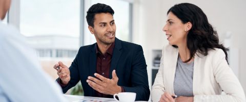 Two people sitting in an office having a discussion.