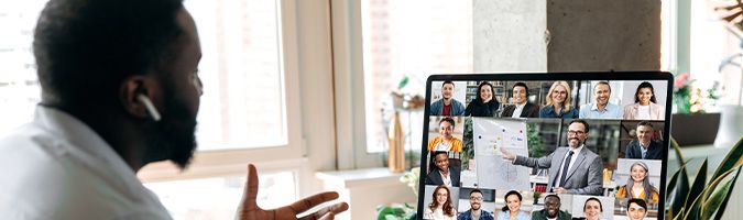 African American successful man, ceo, manager, consultant, holding an online business conference, with multiracial employees, sitting at their desk at home, gesturing hands, discuss about strategy.