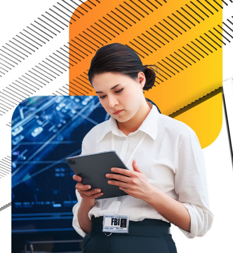 A professional wearing an FBI badge reviews information on a tablet