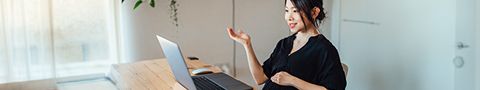 A person sits in front of a laptop participating in video call 