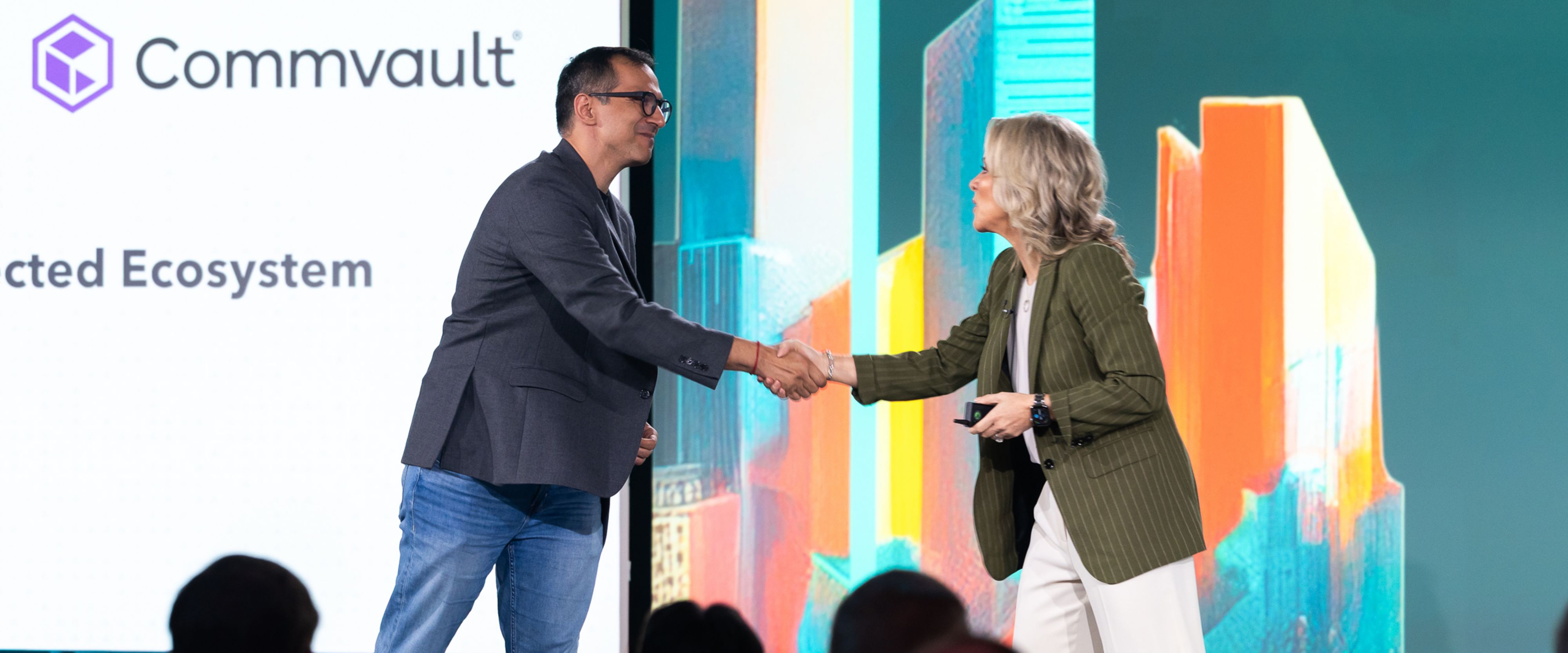 Commvault and Lumen leaders shake hands at Lumen analyst event.