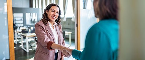 Two people in business attire shaking hands.