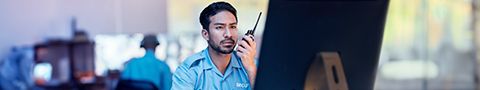 Person in a call center looking at a computer and talking into a handheld device.