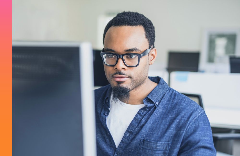 A person works on a desktop computer in an office.