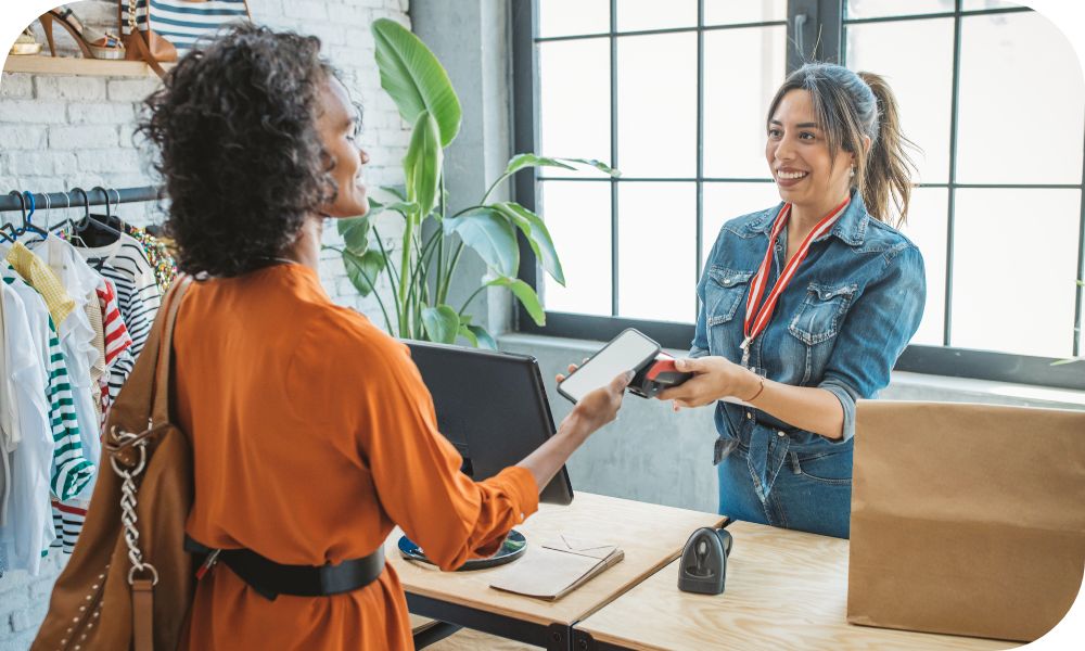 A customer makes a payment to retail clerk using their smart phone for the purchase.