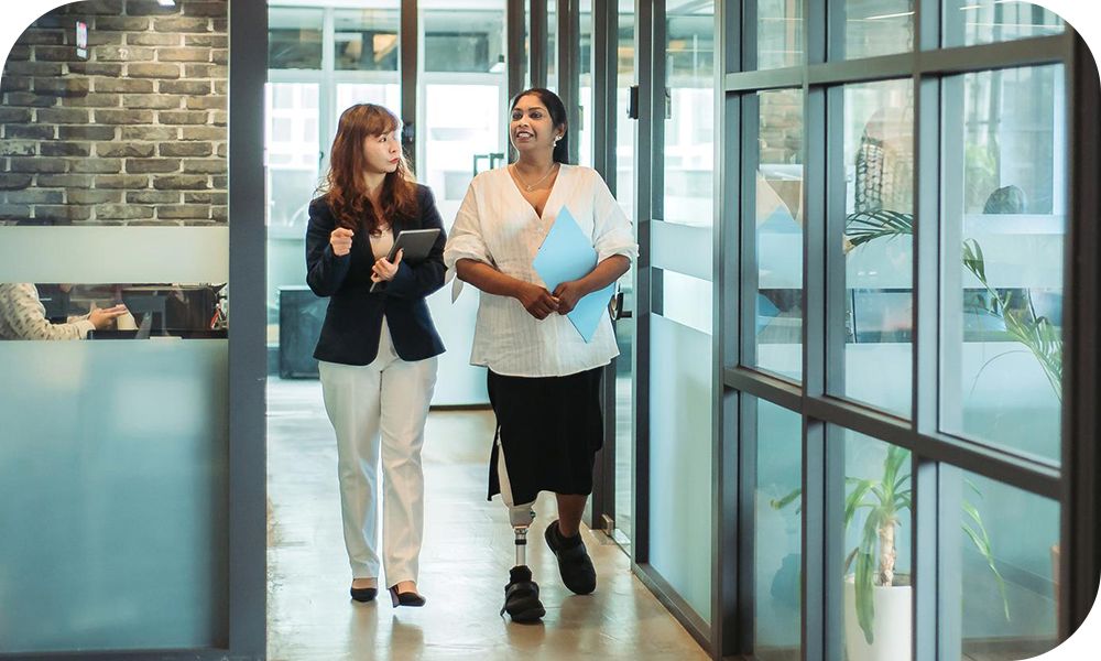 Two businesspeople walk down a hallway