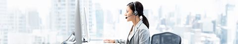 Female call centre professional working at her desktop