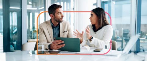 Man holding tablet in business professional discussion with woman.