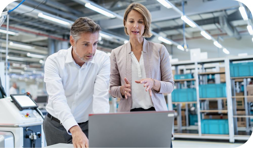 Man and woman in business discussion before an opened laptop