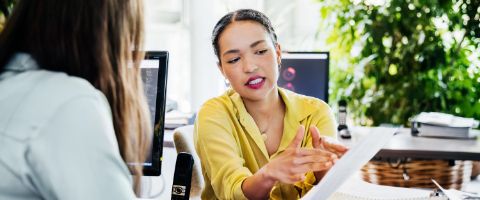 Two people in an office reviewing paperwork 