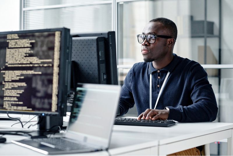 A person works at a desktop computer in an office. 