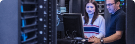 Personas que usan una computadora portátil para monitorear los servidores dentro de un data center
