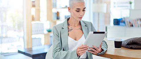 Person with tattoo looking at a tablet. 