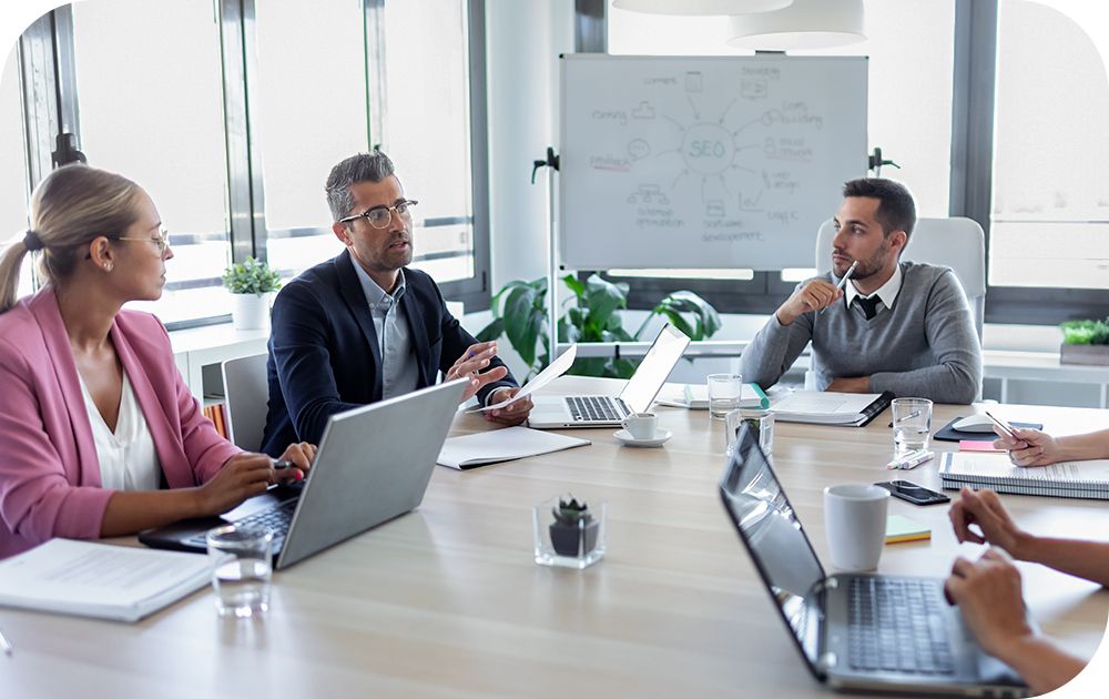 Businesspeople have a meeting sitting at a large table. 