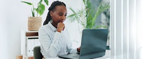 Businesswoman looks at laptop 