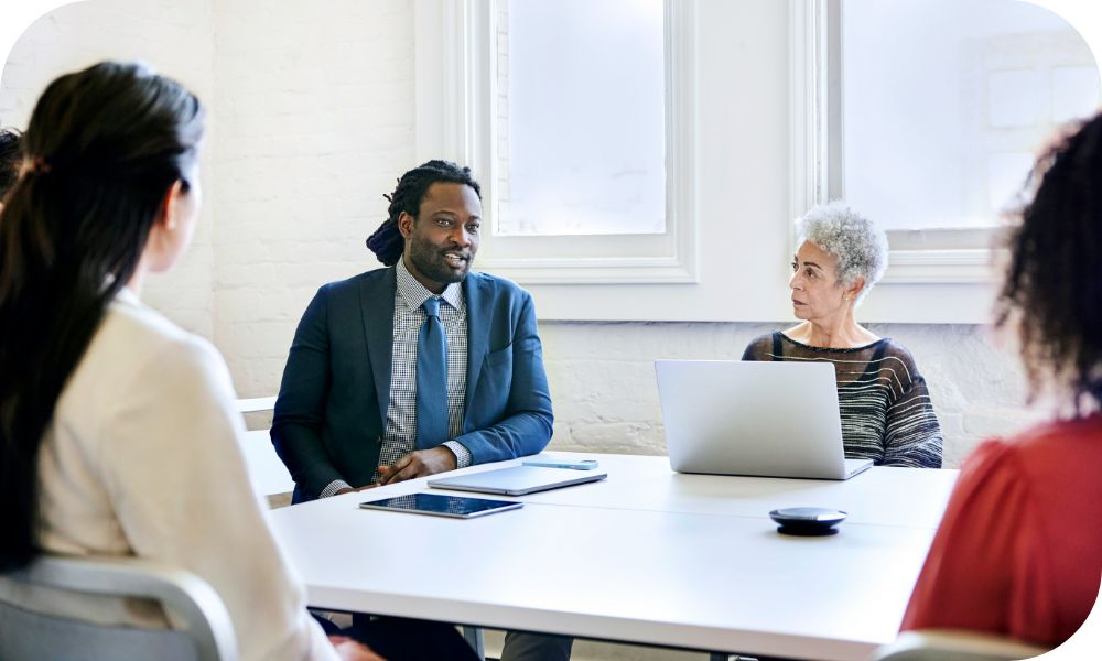 Two people with laptops sitting across from two other people