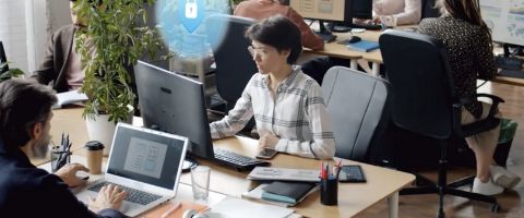 Employees work on their computers in an open office space