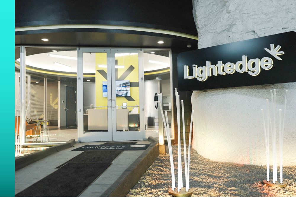 Entrance to the modern office of Lightedge, showing glass double doors and a visible reception area inside.