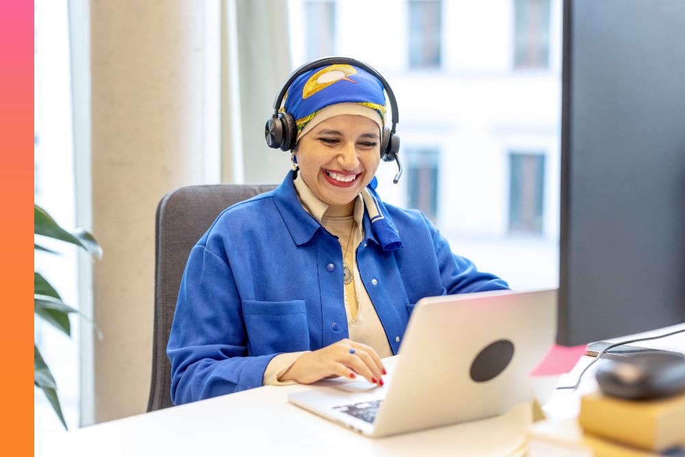 Businessperson sitting and smiling while working on laptop