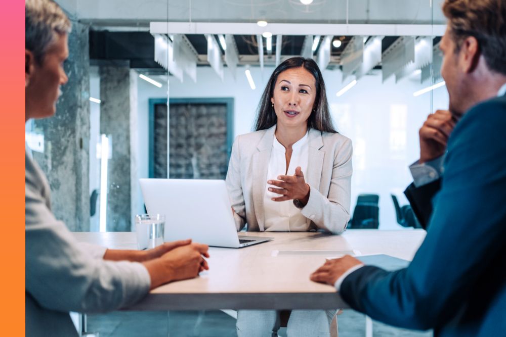 Security specialist discussing issues with two concerned colleagues in conference room outside data center. 