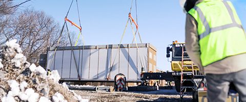 ILA shelter is attached to a crane while a Lumen worker works in forefront