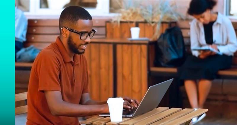 A person in a brightly lit retail store smiles and uses a tablet