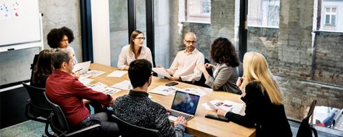 Seven people talking around a conference table