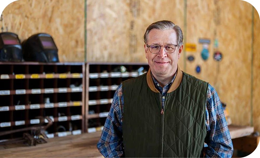 Trenton Thornock, founder and CEO of Prometheus Hyperscale, stands in front of shelves holding a variety of tools. 