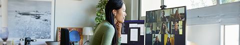 A woman uses video calling software on the computer in a home office