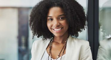 Smiling businesswoman in white suit.