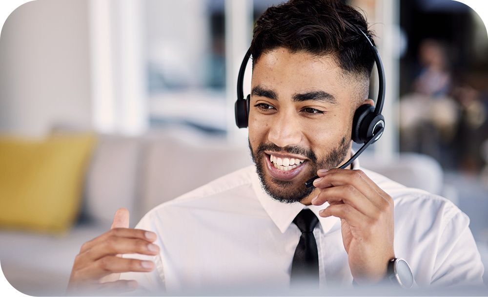 A worker in a white shirt and black tie talks candidly on a headset