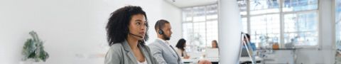 Male and female professionals with phone headsets talking to customers