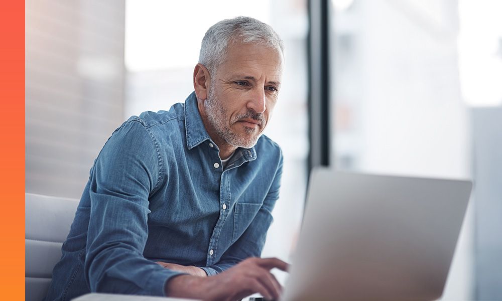 Person sitting at a desk working on a laptop.