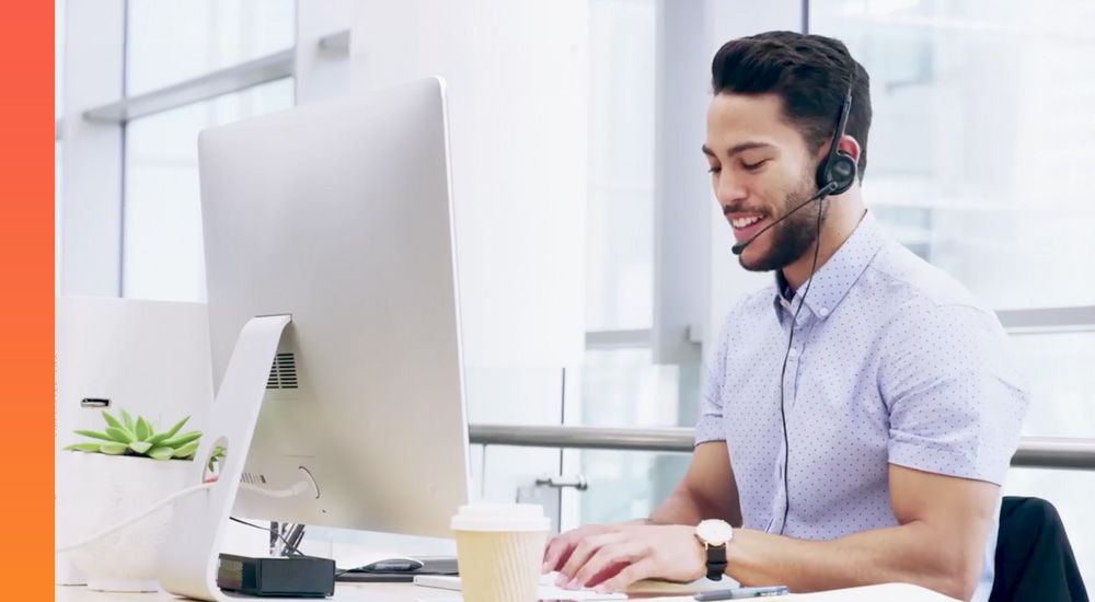 Contact centre agent wearing a headset and sitting at a computer