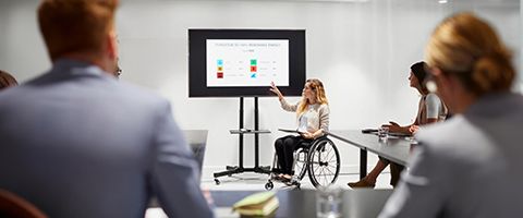 A woman gives a presentation to a crowd.