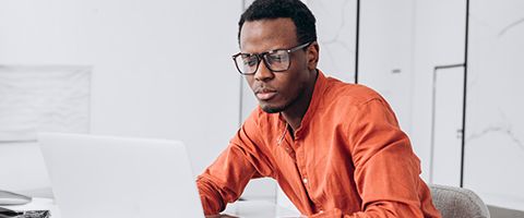  Person working on a laptop in an office. 