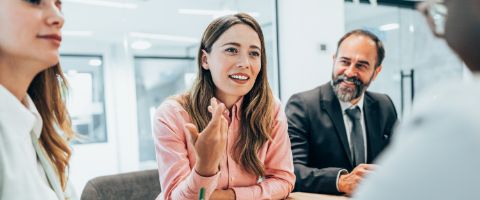 Two people sitting in an office smiling