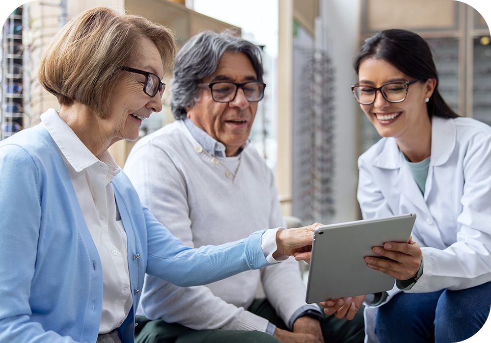 Three people discuss something in reference to a tablet.