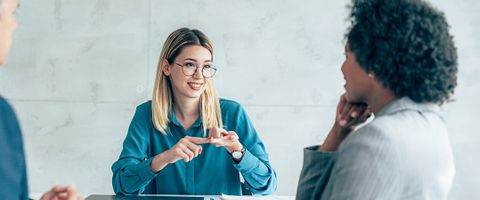 Two women smile while sitting at a desk