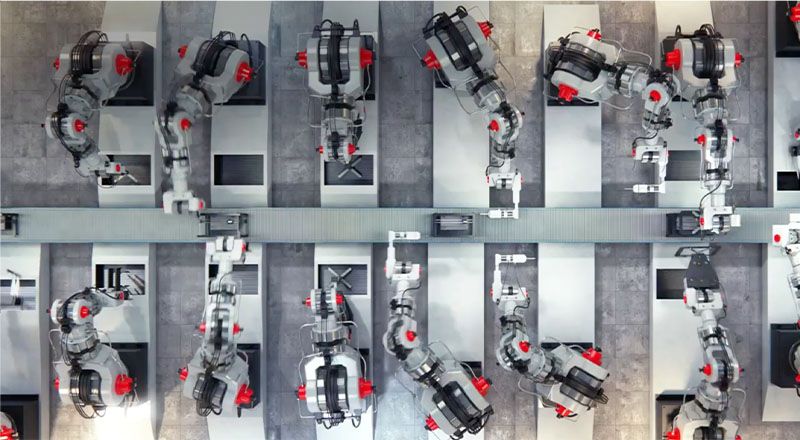 Luftaufnahme von 12 Robotern, die in einer Produktionsanlage arbeiten.
