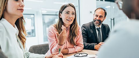 People in a meeting smiling. 