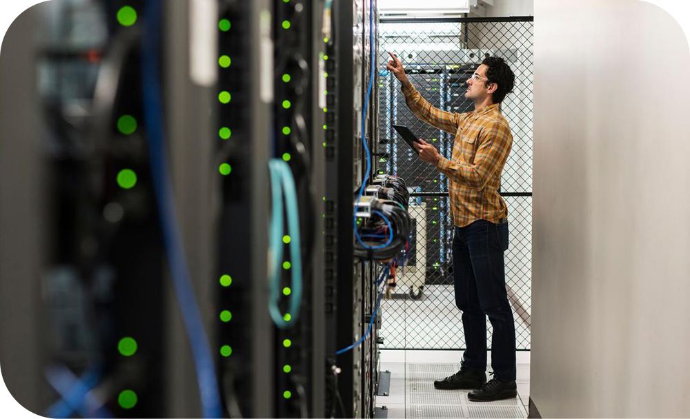 A person works in a server room. 