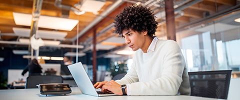 Person working at a laptop in a modern office setting