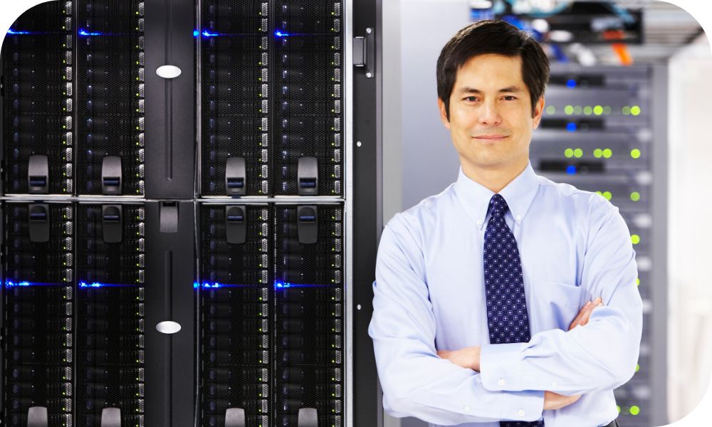 Business man standing with his arms crossed while leaning against a server stack