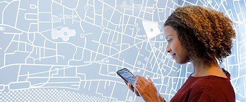 Person holding a smartphone in front of a map.