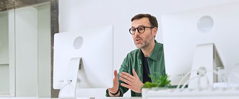 Man looking into computer monitor having a very engaging conversation over Zoom chat. 